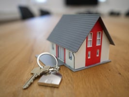 A model home and a key on a table. 