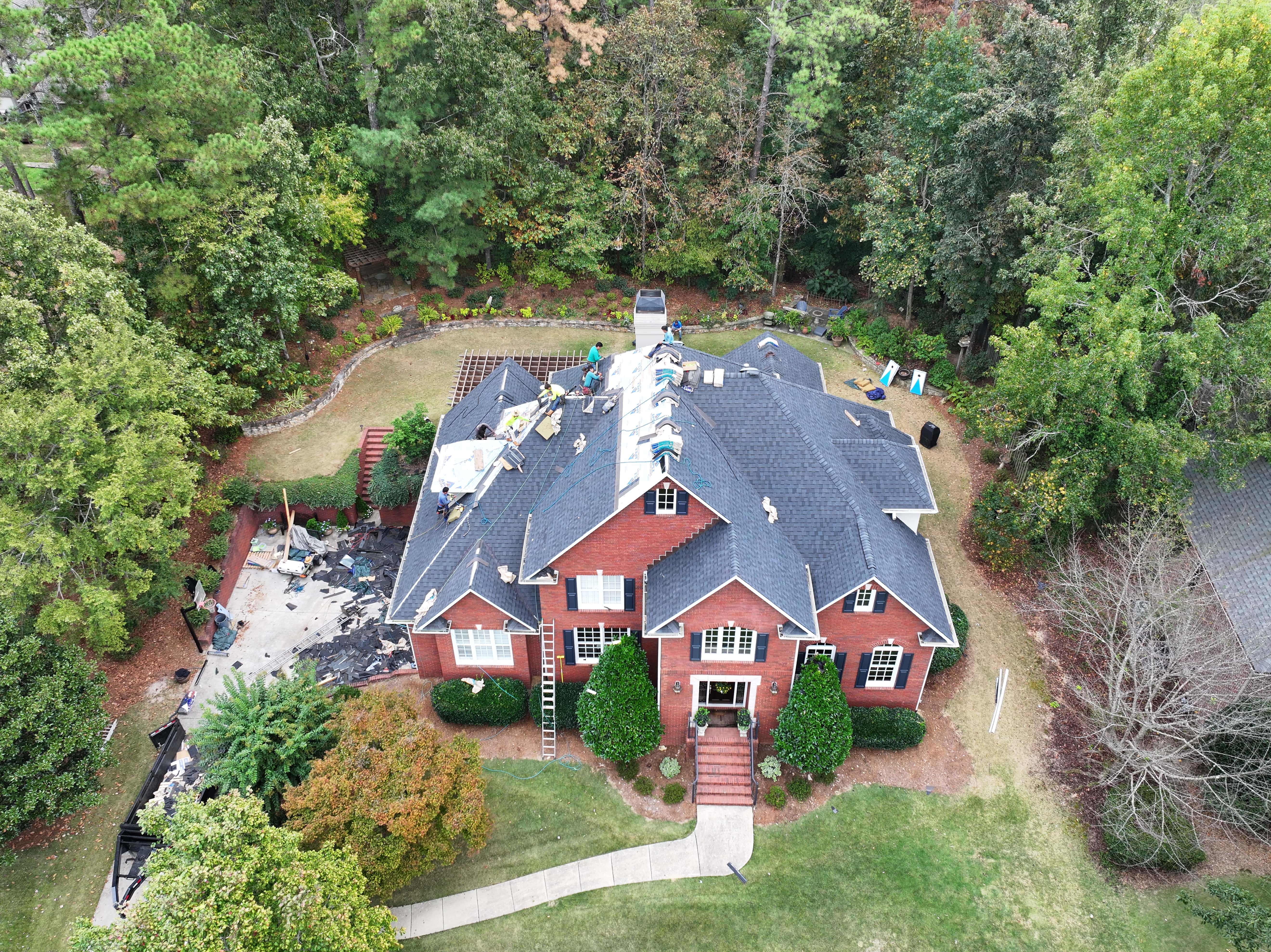Overhead view of brick house in the middle of a roof install.